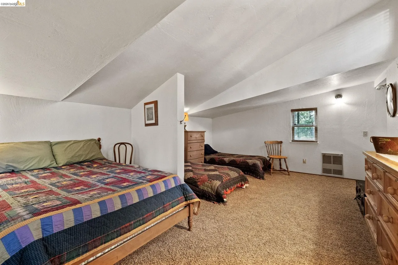 Upstairs loft with two beds under a vaulted ceiling